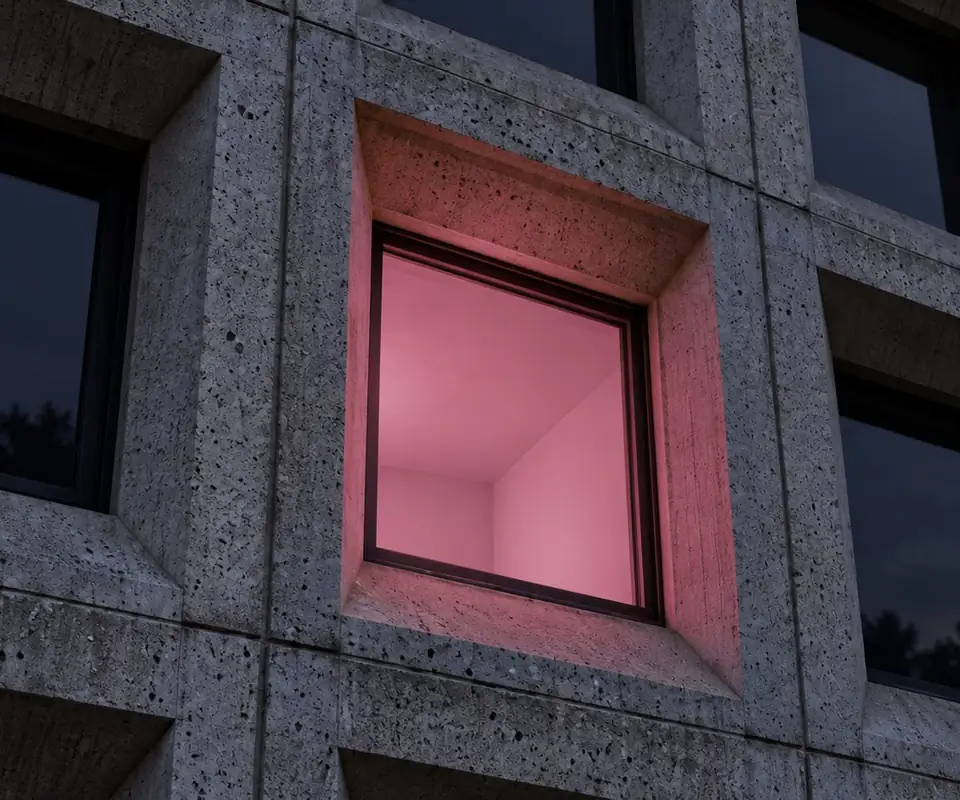 One lit room in a concrete facade at dusk